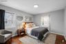 Hardwood flooring throughout featuring a neutral wall color, two windows, and a built-in radiator