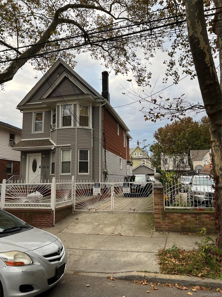 View of front of home with a fenced front yard, a chimney, and a gate
