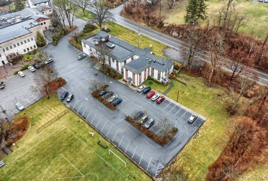 Multi-building complex featuring extensive paved parking areas and a manicured grassy field with goalposts