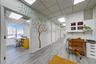 Well-lit interior hallway featuring wood-finish flooring, a drop ceiling with integrated lighting, and multiple open doorways