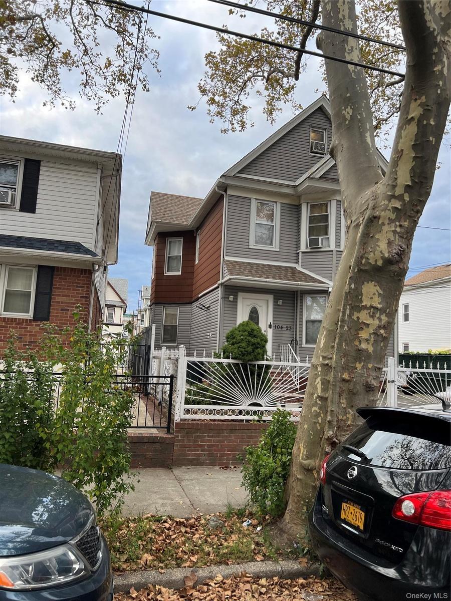 American foursquare style home featuring a fenced front yard and a shingled roof