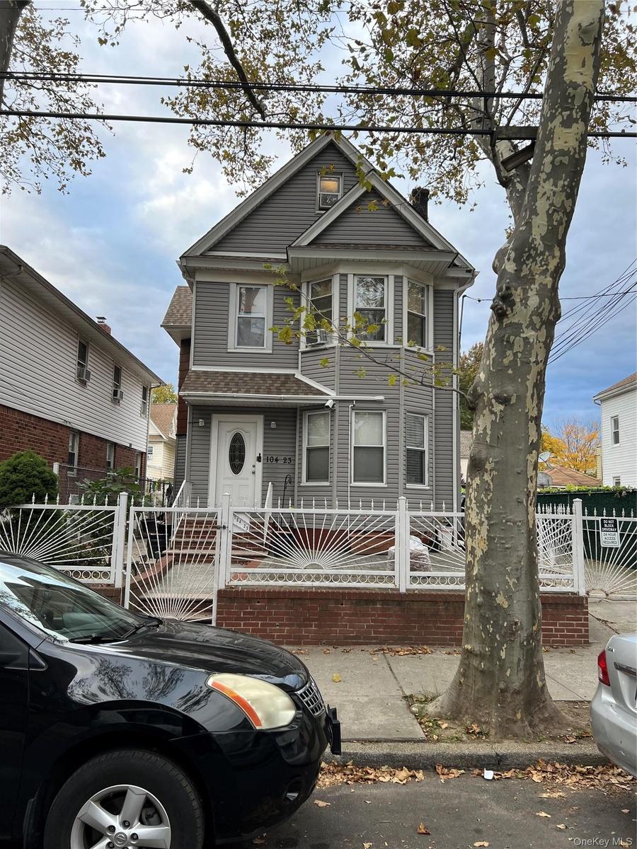 Victorian house with a fenced front yard, a chimney, and a gate