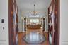 Entryway featuring a notable chandelier, crown molding, light wood-style flooring, ornate columns, and arched walkways
