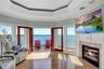 Living area featuring a glass covered fireplace, a raised ceiling, a wealth of natural light, and visible vents