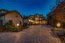 Mediterranean / spanish-style home featuring curved driveway, stucco siding, and a chimney