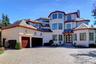 View of front of property with fence, a chimney, decorative driveway, an attached garage, and stucco siding