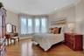 Bedroom with crown molding, light wood finished floors, and baseboards