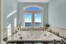 Full bath with a healthy amount of sunlight, a jetted tub, and a water view