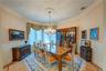 Dining room with visible vents, crown molding, light wood-type flooring, a wainscoted wall, and an inviting chandelier