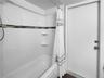 Guest bathroom with updated tile, porcelain tile floor, and tub