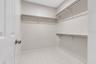 Virtually staged walk- in closet in primary bedroom