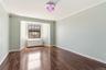 Room featuring wood-finish flooring, light-toned wall paint, and white baseboards