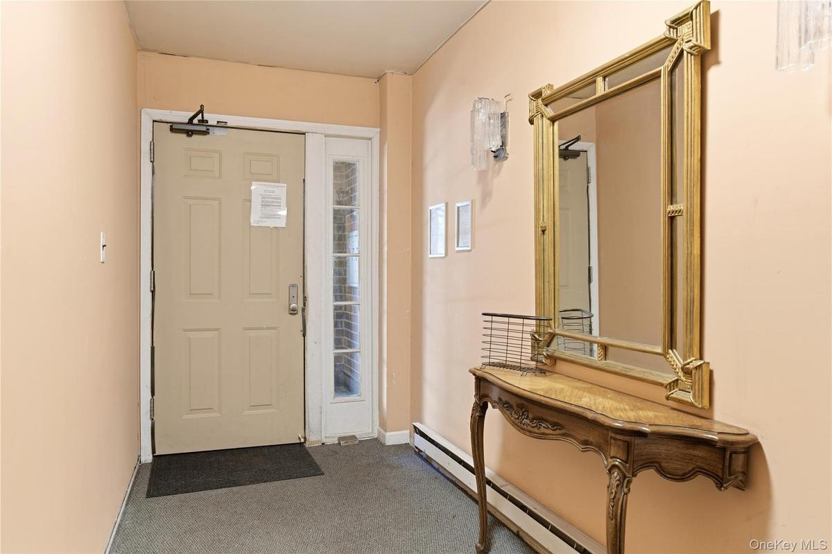 Entry area featuring a solid panel door with sidelight, neutral wall paint, and carpet flooring