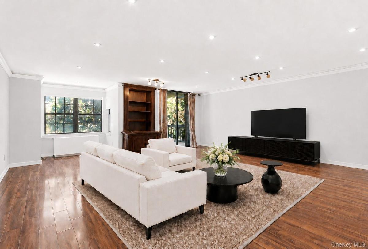 Spacious living area featuring wood-finish flooring, recessed lighting, and crown molding