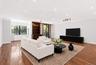 Spacious living area featuring wood-finish flooring, recessed lighting, and crown molding