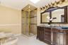 Double vanity with ornate wood cabinetry, dual undermount sinks, and a stone-finish countertop