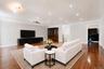 Living area featuring rich wood-finish flooring, recessed lighting, crown molding, and a built-in display cabinet