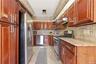 Galley kitchen with cherry wood-finish cabinetry and stainless steel appliances