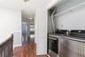 Convenient laundry area featuring bi-fold louvered doors and overhead shelving