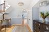 Inviting entryway featuring hardwood flooring, a detailed wooden staircase, and built-in closet storage