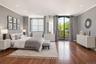 Expansive room featuring rich wood-finish flooring, recessed lighting, and a large arched glass door opening to a balcony