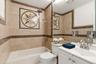 Full bathroom featuring a tiled shower and bath combination with a decorative compass rose accent