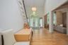 Two-story foyer featuring hardwood flooring, a prominent staircase with white risers and wood treads, a vaulted ceiling, and an arched transom window 