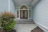 Exterior facade featuring light blue horizontal siding, a flagstone walkway, and flagstone steps leading to a dual red entry door with sidelights and 