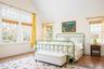 Bedroom with multiple windows, lofted ceiling, baseboards, and wood finished floors