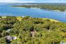 Aerial view of property's location with a forest and a large body of water