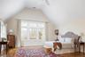 Bedroom featuring a ceiling fan, wood finished floors, visible vents, high vaulted ceiling, and baseboards