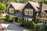 Shingle-style home featuring a standing seam roof, a chimney, roof with shingles, and a metal roof