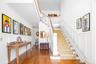 Staircase with wood finished floors, ornamental molding, and a decorative wall