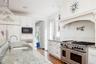 Kitchen featuring built in microwave, ornamental molding, range with two ovens, wood finished floors, and a sink