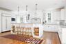 Kitchen with open shelves, light wood-style flooring, tasteful backsplash, and built in appliances