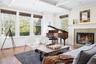 Living room with beamed ceiling, coffered ceiling, wood finished floors, and crown molding