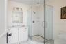 Full bath with a wainscoted wall, toilet, a stall shower, and ornamental molding