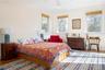 Bedroom with crown molding, wood finished floors, baseboards, and ceiling fan