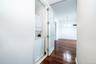 Corridor featuring stacked washer / dryer, dark wood-style floors, and a chandelier