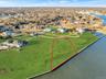 Aerial view of residential area with property parcel outlined and a nearby body of water