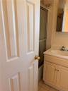 Bathroom vanity with integrated sink and chrome faucet, tile flooring, and a mirrored medicine cabinet