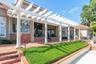 Lush landscaping and detail with an abundance of St. Louis brick and impressive pergola