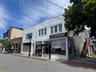 The building features two street-level retail storefronts and a spacious residential apartment above, creating multiple income streams and long-term v