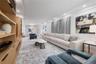 Living room featuring custom built-in wood cabinetry and shelving, recessed lighting, expansive windows with custom automated treatments, leading to o