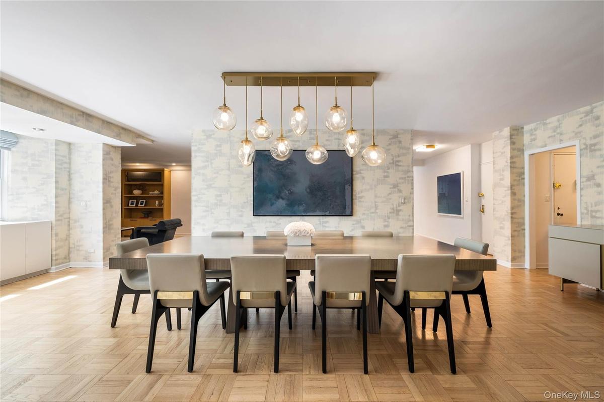 Dining space featuring parquet flooring, patterned wallpaper, and built-in window storage