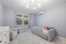 Bedoom featuring dual windows, a ceiling-mounted light fixture, a split system, and baseboard trim