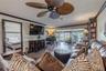 Multiple seating areas in the living room offer flexibility and function, all oriented toward the home’s beautiful waterfront backdrop.