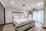The primary bedroom feels open and inviting with warm natural light and ceramic tile flooring.