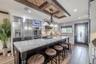 Custom cabinetry, under-cabinet lighting, and a pot filler combine functionality and style, while the built-in TV nook keeps the space perfect for ent