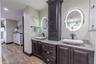 The primary bath showcases stunning split vanities with stone countertops, LED lighted mirrors, and custom water faucets chosen for their sleek and ar
